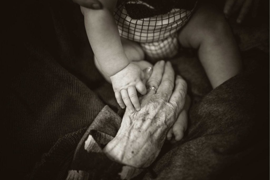 Better Aging - Hand einer alten Frau und Kinderhand