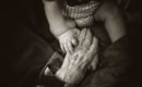 Better Aging - Hand einer alten Frau und Kinderhand
